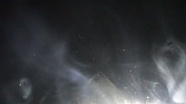 Vape kavramı. Duman bulutları ve vape sıvı şişe koyu arka plan üzerinde. Işık efektleri. Arka plan veya vape reklam veya vape arka plan olarak yararlı.