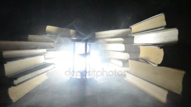 Bir yığın halinde birçok eski kitaplar. Knoledge kavramı. Duman elemanları ile karanlık bir arka plan üzerinde kitaplar. Merkezi büyülenmiş kitapta. Glasswatch