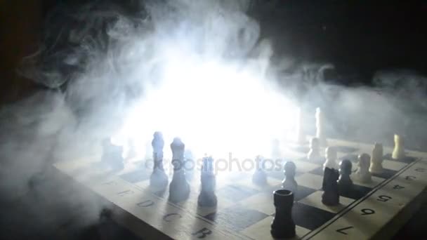 Концепция шахматной настольной игры бизнес-идей, конкуренции и стратегических идей. Шахматные фигуры на темном фоне с дымом и туманом. Селективный фокус — стоковое видео