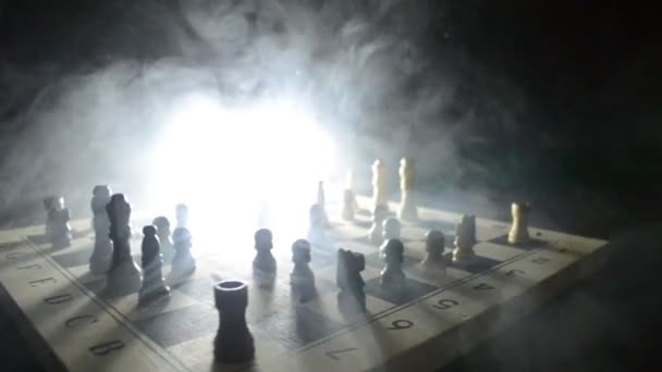 Chess board game concept of business ideas and competition and strategy ideas concep. Chess figures on a dark background with smoke and fog. Selective focus — Stock Video