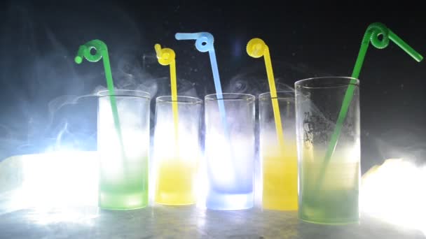 Five cocktails on the bar with smoke on dark background. Yellow, green and blue colored glasses. Club drinks — Stock Video