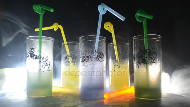 Five cocktails on the bar with smoke on dark background. Yellow, green and blue colored glasses. Club drinks — Stock Video