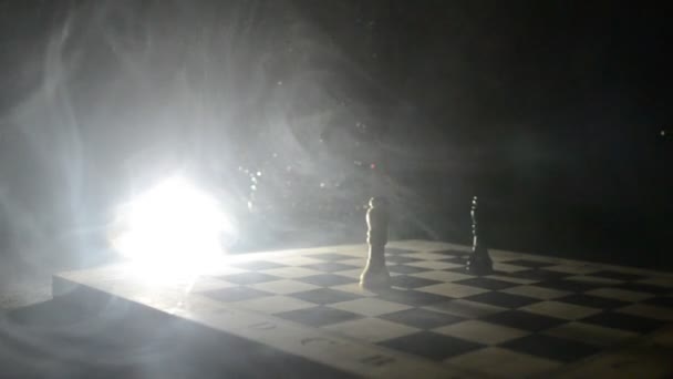 Jeu d'échiquier concept d'idées d'affaires et de la concurrence et des idées de stratégie concéder. Chess figures sur un fond sombre avec de la fumée et du brouillard. Concentration sélective — Video