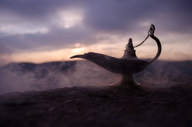 Zanaat Aladdin Arabian nights cin stili yağ lambası yumuşak ışık beyaz duman ile antika. Gün batımı dağ arka plan