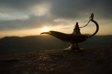 Zanaat Aladdin Arabian nights cin stili yağ lambası yumuşak ışık beyaz duman ile antika. Gün batımı dağ arka plan