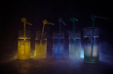 Koyu arka plan üzerinde duman ile beş kokteyl Çubuğu'nda. Sarı, yeşil ve mavi renkli gözlük.