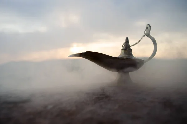 Антикварная ремесленная арабская ночь Аладдина в стиле джинна масляная лампа с мягким белым дымом. Закат горы — стоковое фото