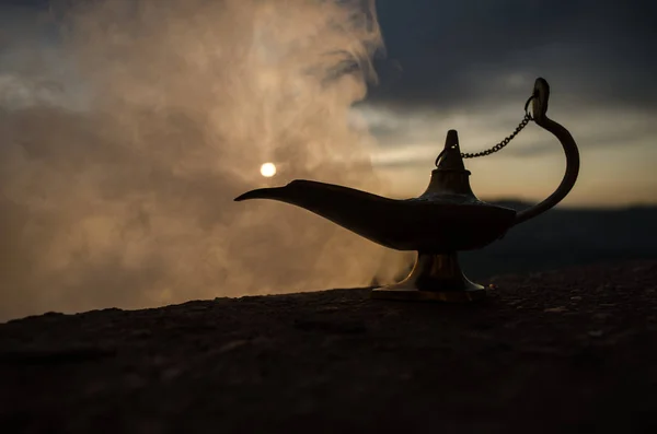Zanaat Aladdin Arabian nights cin stili yağ lambası yumuşak ışık beyaz duman ile antika. Gün batımı dağ arka plan — Stok fotoğraf