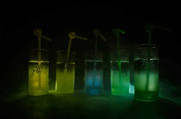 Cinco cocktails no bar com fumo no fundo escuro. Amarelo, verde e azul óculos coloridos . — Fotografia de Stock