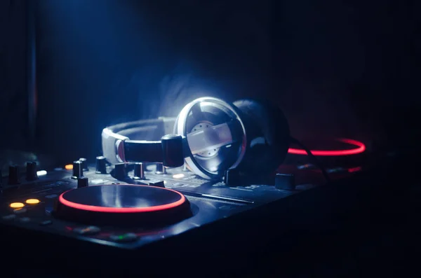 DJ spinnen, mixen en scratchen in een nachtclub, handen van dj tweak van de verschillende besturingselementen van het nummer op deck van de dj's, strobe lights en mist, selectieve aandacht, close-up. DJ Music club life — Stockfoto