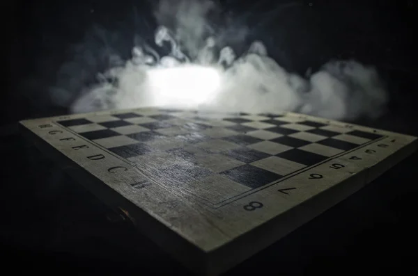 Chess board game concept of business ideas and competition and strategy ideas concep. Chess figures on a dark background with smoke and fog. — Stock Photo, Image
