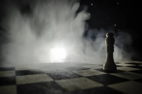 Jeu d'échiquier concept d'idées d'affaires et de la concurrence et des idées de stratégie concéder. Figures d'échecs sur un fond sombre avec de la fumée et du brouillard . — Photo