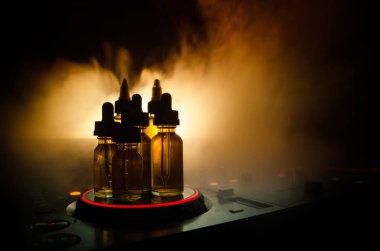 Vape ve Dj Club kavramı. Duman bulutları ve Dj Mikser yakın çekim vape sıvı şişe. Işık efektleri. Arka plan veya vape veya kulüp reklam ya da vape arka plan olarak yararlı.