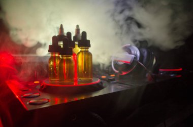 Vape ve Dj Club kavramı. Duman bulutları ve Dj Mikser yakın çekim vape sıvı şişe. Işık efektleri. Arka plan veya vape veya kulüp reklam ya da vape arka plan olarak yararlı.