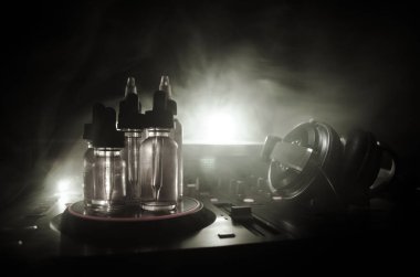 Vape ve Dj Club kavramı. Duman bulutları ve Dj Mikser yakın çekim vape sıvı şişe. Işık efektleri. Arka plan veya vape veya kulüp reklam ya da vape arka plan olarak yararlı.