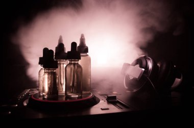Vape ve Dj Club kavramı. Duman bulutları ve Dj Mikser yakın çekim vape sıvı şişe. Işık efektleri. Arka plan veya vape veya kulüp reklam ya da vape arka plan olarak yararlı.