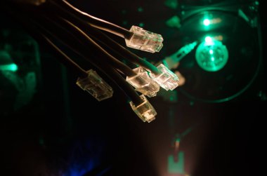 Ağ anahtarı ve ethernet kabloları, global iletişim sembolüdür. Işıklar ve duman ile koyu arka plan üzerinde renkli ağ kabloları. Seçici odak