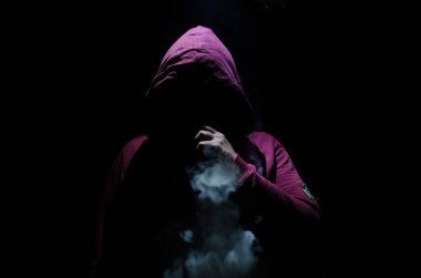Bir mod tutarak Vaping adam. Buhar bulutu. Siyah arka plan. Vaping çok duman ile elektronik sigara.