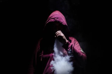 Bir mod tutarak Vaping adam. Buhar bulutu. Siyah arka plan. Vaping çok duman ile elektronik sigara.