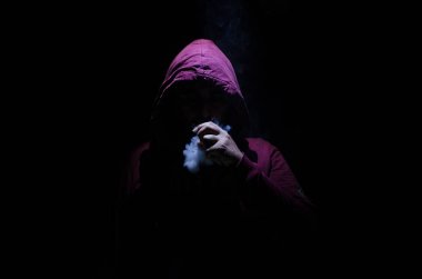 Bir mod tutarak Vaping adam. Buhar bulutu. Siyah arka plan. Vaping çok duman ile elektronik sigara.
