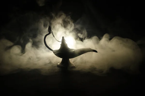 Antiguo Aladdin noches árabes lámpara de aceite de estilo genio con humo blanco claro suave, fondo oscuro. Concepto de lámpara de deseos. Tonificado —  Fotos de Stock