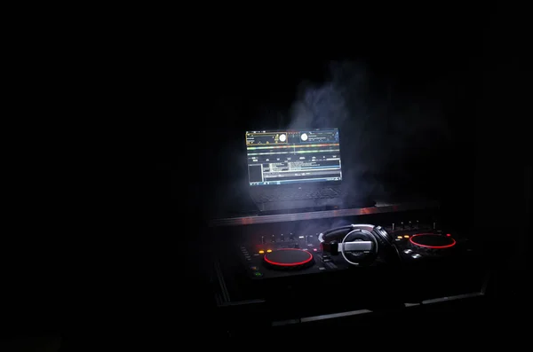 DJ Spinning, Mixing, and Scratching in a Night Club, Hands of dj tweak various track controls on dj's deck, strobe lights and fog, selective focus, close up. Dj Music club life concept — Stock Photo, Image