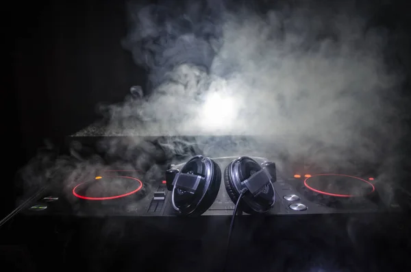 DJ Spinning, Mixing, and Scratching in a Night Club, Hands of dj tweak vari controlli delle tracce sul ponte del DJ, luci stroboscopiche e nebbia, messa a fuoco selettiva, da vicino. Concetto di vita del Dj Music club — Foto Stock