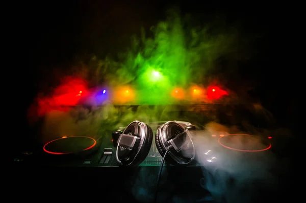 DJ Spinning, Mixing, and Scratching in a Night Club, Hands of dj tweak vari controlli delle tracce sul ponte del DJ, luci stroboscopiche e nebbia, messa a fuoco selettiva, da vicino. Concetto di vita del Dj Music club — Foto Stock