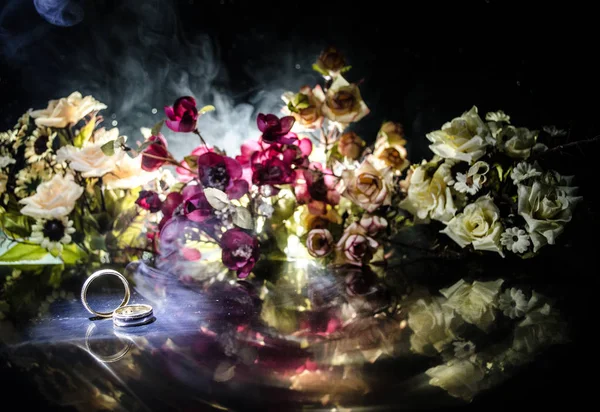 Tarjeta de boda, anillos de boda. Ramo de bodas, fondo. Rama de flores con delicadas flores blancas en la superficie de madera. Declaración de amor, primavera. Fondo oscuro con humo y corazón . — Foto de Stock