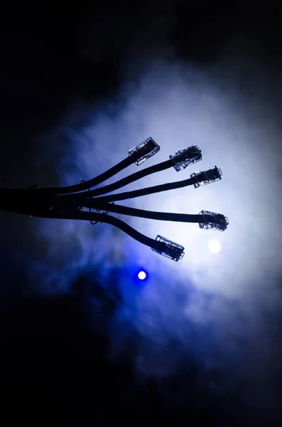 Netzwerk-Switch und Ethernet-Kabel, Symbol der globalen Kommunikation. farbige Netzwerkkabel auf dunklem Hintergrund mit Licht und Rauch. Selektiver Fokus — Stockfoto