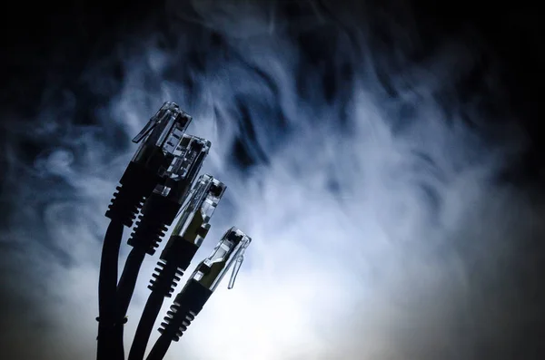 Network switch and ethernet cables, symbol of global communications. Colored network cables on dark background with lights and smoke. Selective focus — Stock Photo, Image