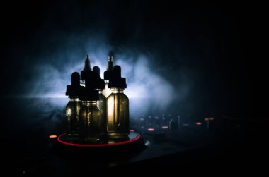 Vape ve Dj Club kavramı. Duman bulutları ve Dj Mikser yakın çekim vape sıvı şişe. Işık efektleri. Arka plan veya vape veya kulüp reklam ya da vape arka plan olarak yararlı.