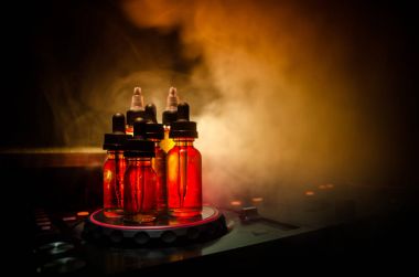 Vape ve Dj Club kavramı. Duman bulutları ve Dj Mikser yakın çekim vape sıvı şişe. Işık efektleri. Arka plan veya vape veya kulüp reklam ya da vape arka plan olarak yararlı.