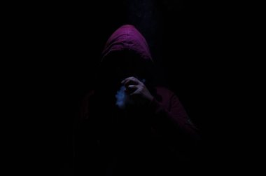 Bir mod tutarak Vaping adam. Buhar bulutu. Siyah arka plan. Vaping çok duman ile elektronik sigara