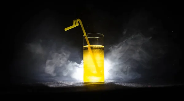 Ярко-желтый зеленый коктейль украшенный лаймом. Классические алкогольные коктейли, алкогольные напитки, безалкогольные напитки, вкусные коктейли на тёмном фоне с дымом и светом — стоковое фото