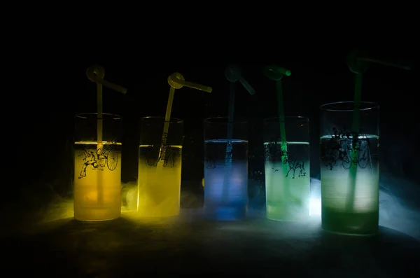 Öt koktélokat a bárban, füst, sötét háttér. Sárga, zöld és kék színű üvegek. — Stock Fotó