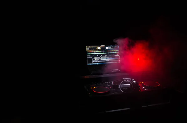 DJ Spinning, Mixing, and Scratching in a Night Club, Hands of dj tweak vari controlli delle tracce sul ponte del DJ, luci stroboscopiche e nebbia, messa a fuoco selettiva, da vicino. Concetto di vita del Dj Music club — Foto Stock