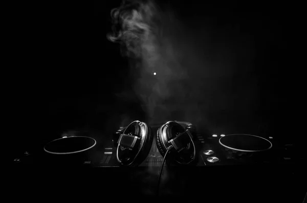 DJ Spinning, Mixing, and Scratching in a Night Club, Hands of dj tweak vari controlli delle tracce sul ponte del DJ, luci stroboscopiche e nebbia, messa a fuoco selettiva, da vicino. Concetto di vita del Dj Music club — Foto Stock