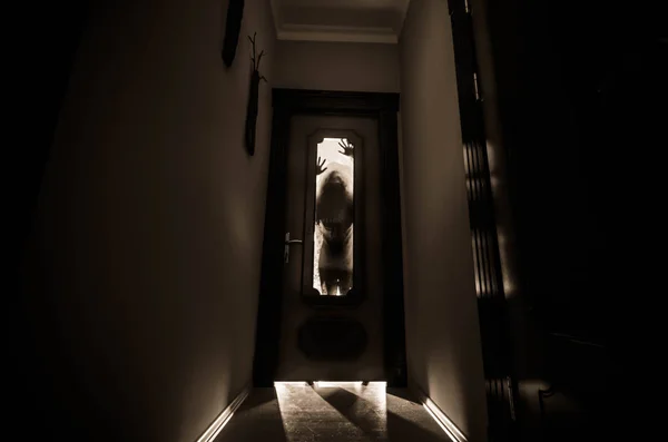 不明な影図のシルエットは、閉じたガラスのドアを通ってドアを手します。ホラー コンセプト — ストック写真