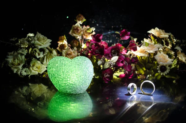 Tarjeta de boda, anillos de boda. Ramo de bodas, fondo. Rama de flores con delicadas flores blancas en la superficie de madera. Declaración de amor, primavera. Fondo oscuro con humo y corazón . — Foto de Stock