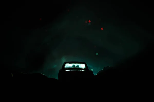 Silhouette de voiture avec couple à l'intérieur sur fond sombre avec des lumières et de la fumée. Scène romantique. Concept d'amour — Photo