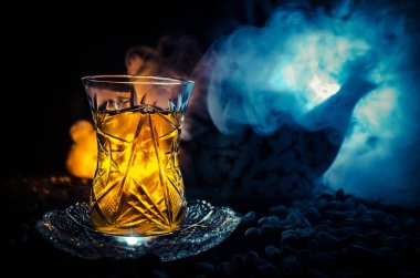 Geleneksel glasse ve ışıklar ve duman siyah zemin üzerine pot Türk Azerbaycan tea. Armudu geleneksel Kupası