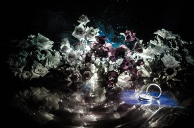 Düğün kartı, nikah yüzükleri. Düğün buketi, arka plan. Ahşap yüzey üzerinde beyaz narin çiçekler ile şube çiçeklenme. Bildirim sevgisi, Bahar. Duman ve kalp ile koyu arka plan.