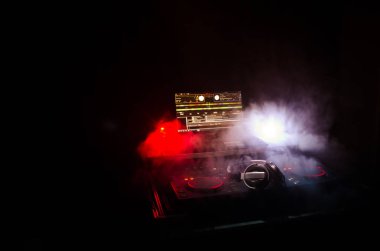 DJ iplik, karıştırma ve tırmalamak dj elinde bir gece kulübünde dj's güverte, strobe ışıklar ve sis, seçici odak çeşitli parça denetimlere tweak, yakın çekim. DJ müzik kulübü hayat kavramı