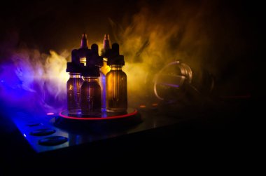 Vape ve Dj Club kavramı. Duman bulutları ve Dj Mikser yakın çekim vape sıvı şişe. Işık efektleri. Arka plan veya vape veya kulüp reklam ya da vape arka plan olarak yararlı.