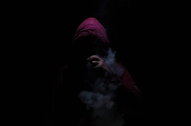 Bir mod tutarak Vaping adam. Buhar bulutu. Siyah arka plan. Vaping çok duman ile elektronik sigara