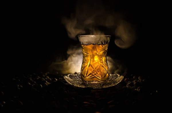 Turkish Azerbaijan tea in traditional glasse and pot on black background with lights and smoke. Armudu traditional cup — Stock Photo, Image