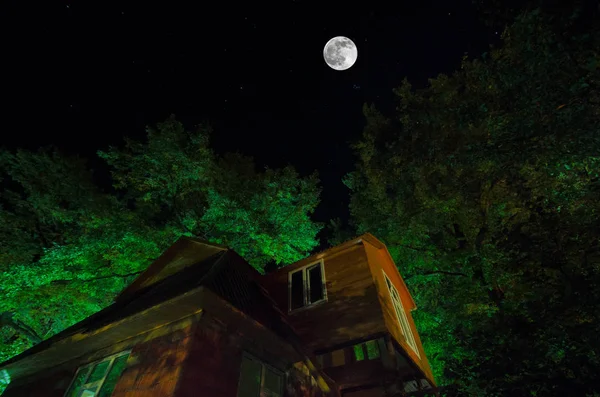 Красивий краєвид село вулиці з будівель і дерев і великий повний місяць в нічне небо. Великий Кавказ . — стокове фото