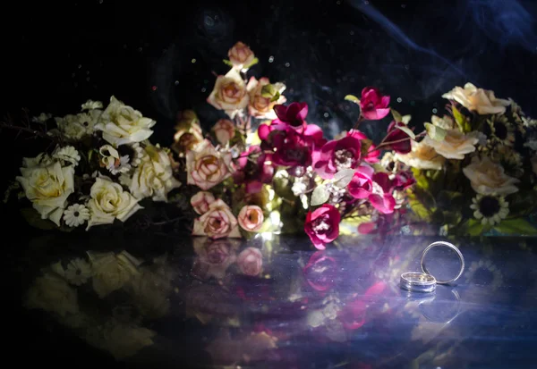 Wedding card, Wedding rings. Wedding bouquet, background. Flowering branch with white delicate flowers on wooden surface. Declaration of love, spring. Dark background with smoke and heart.