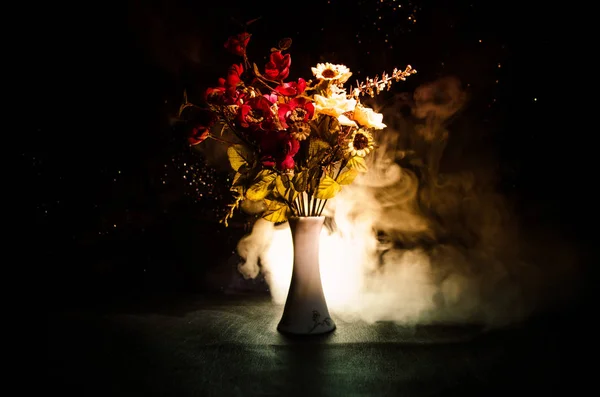 Pintorescas flores de primavera púrpura en jarrón de vidrio de pie en una fila sobre un fondo oscuro con estrellas con luz y niebla. De cerca. — Foto de Stock